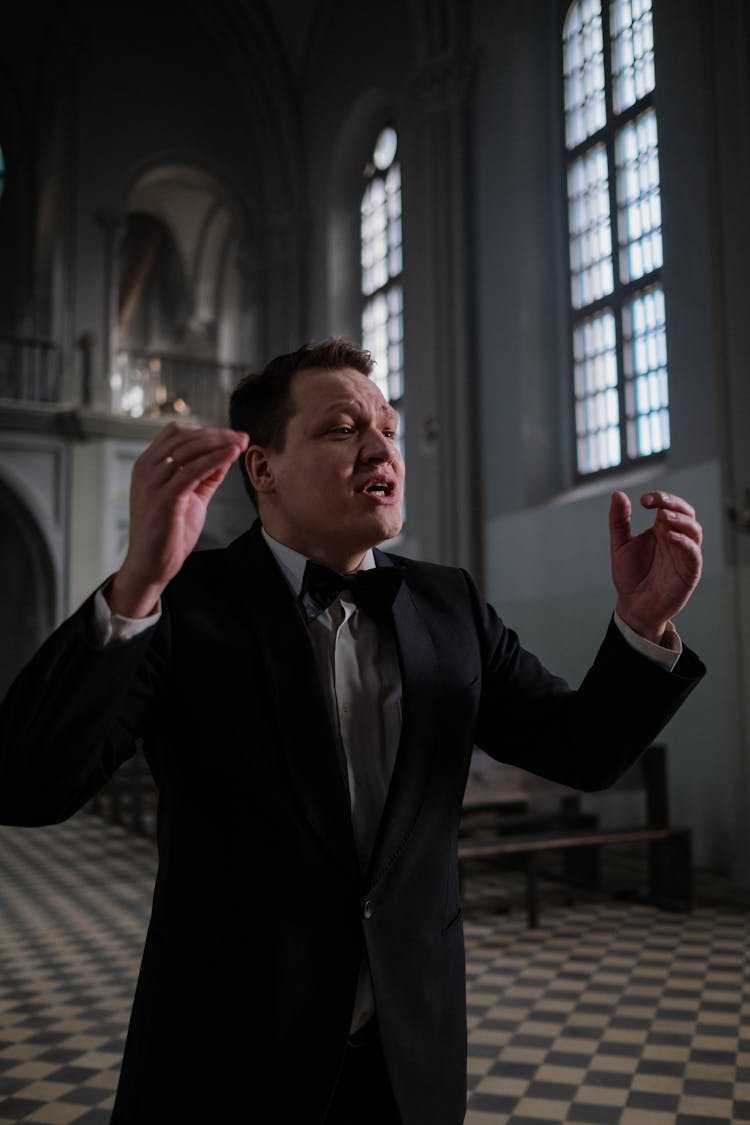 Choir Conductor In Black Suit Jacket With Bowtie Doing Hand Signal