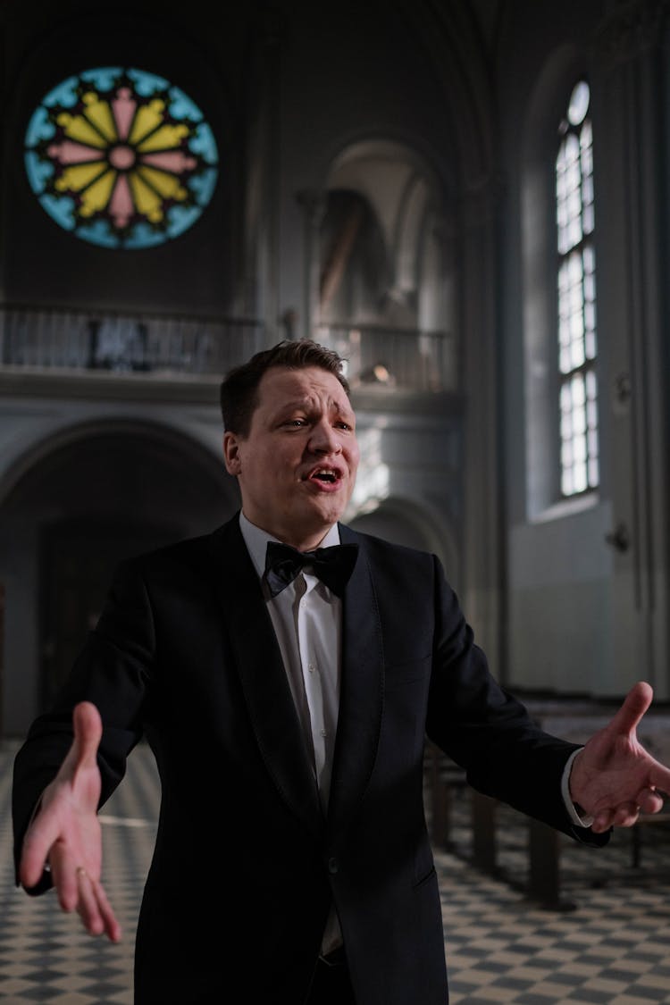 Choir Conductor In Black Suit Jacket With Bowtie Doing A Hand Signal