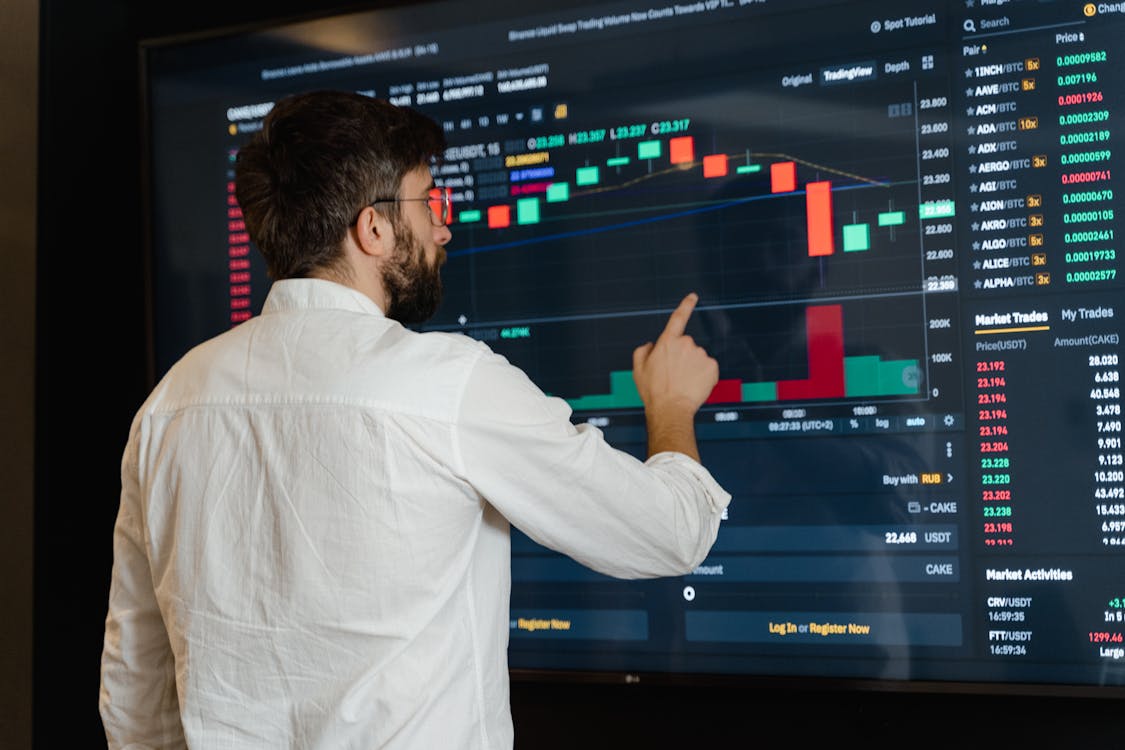 Free Man in White Dress Shirt Analyzing Data Displayed on Screen Stock Photo