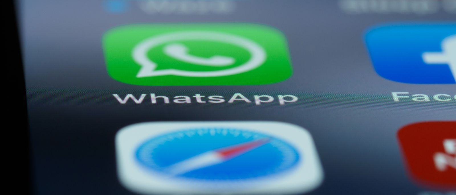Detailed close-up of a smartphone's home screen displaying popular applications like WhatsApp.