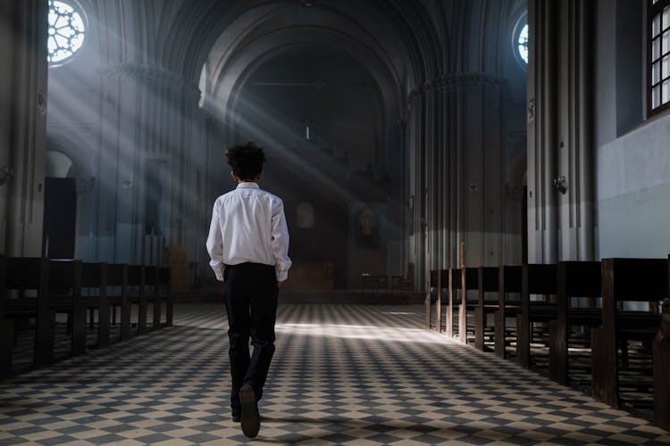 Back View Of A Person Walking On The Church Aisle