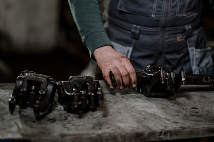 Greasy Hand Holding Black Metallic Spare Parts