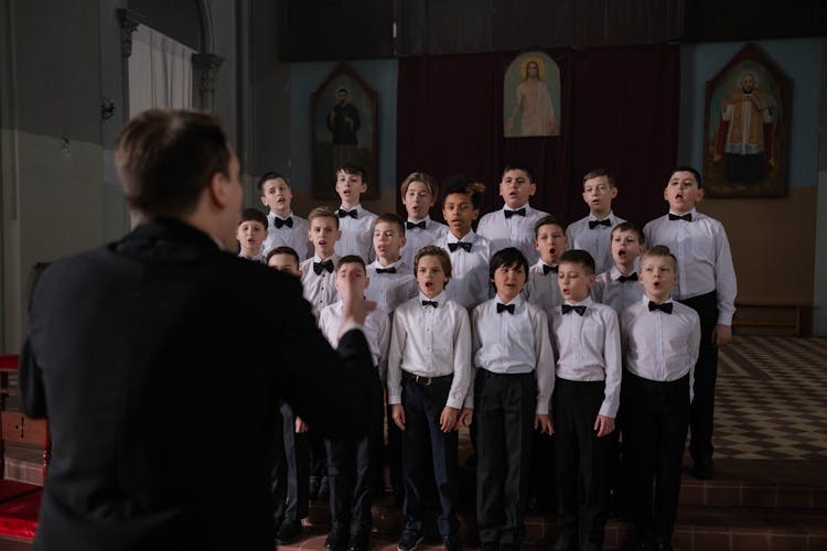 A Conductor Leading A Boys Choir