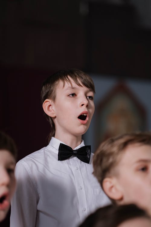 Free Boy in White Shirt and Black Bowtie Singing Stock Photo