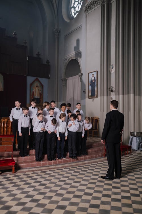 Man in Black Suit Standing In Front of Boys