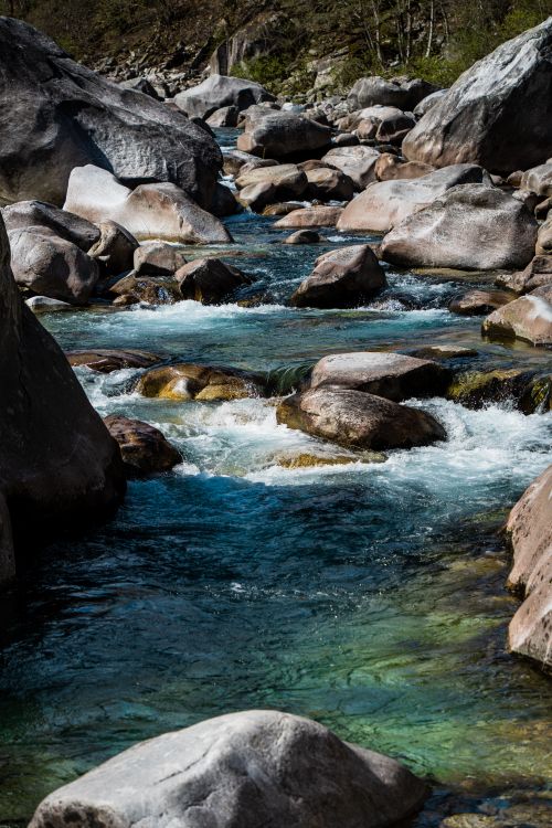 Free Clear turquoise waters cascade over rocks in Lavertezzo, Switzerland. Stock Photo