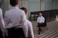 Man Sitting On Wooden Chair In Front Of A Boy Choir