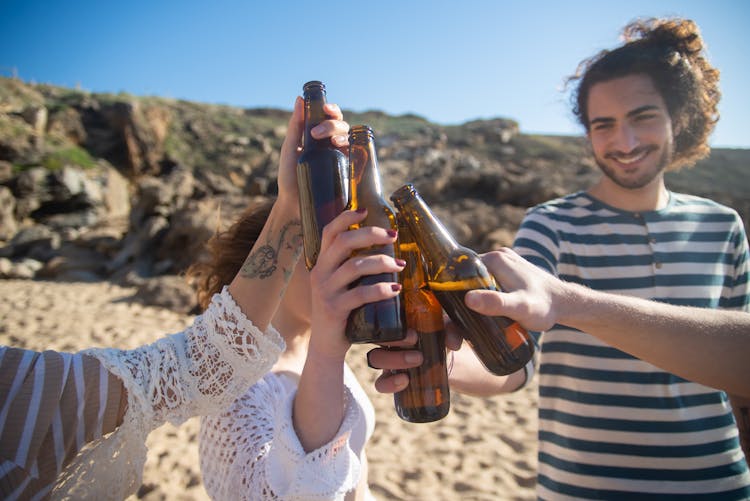 A Group Of Friends Toasting Their Beer Bottles