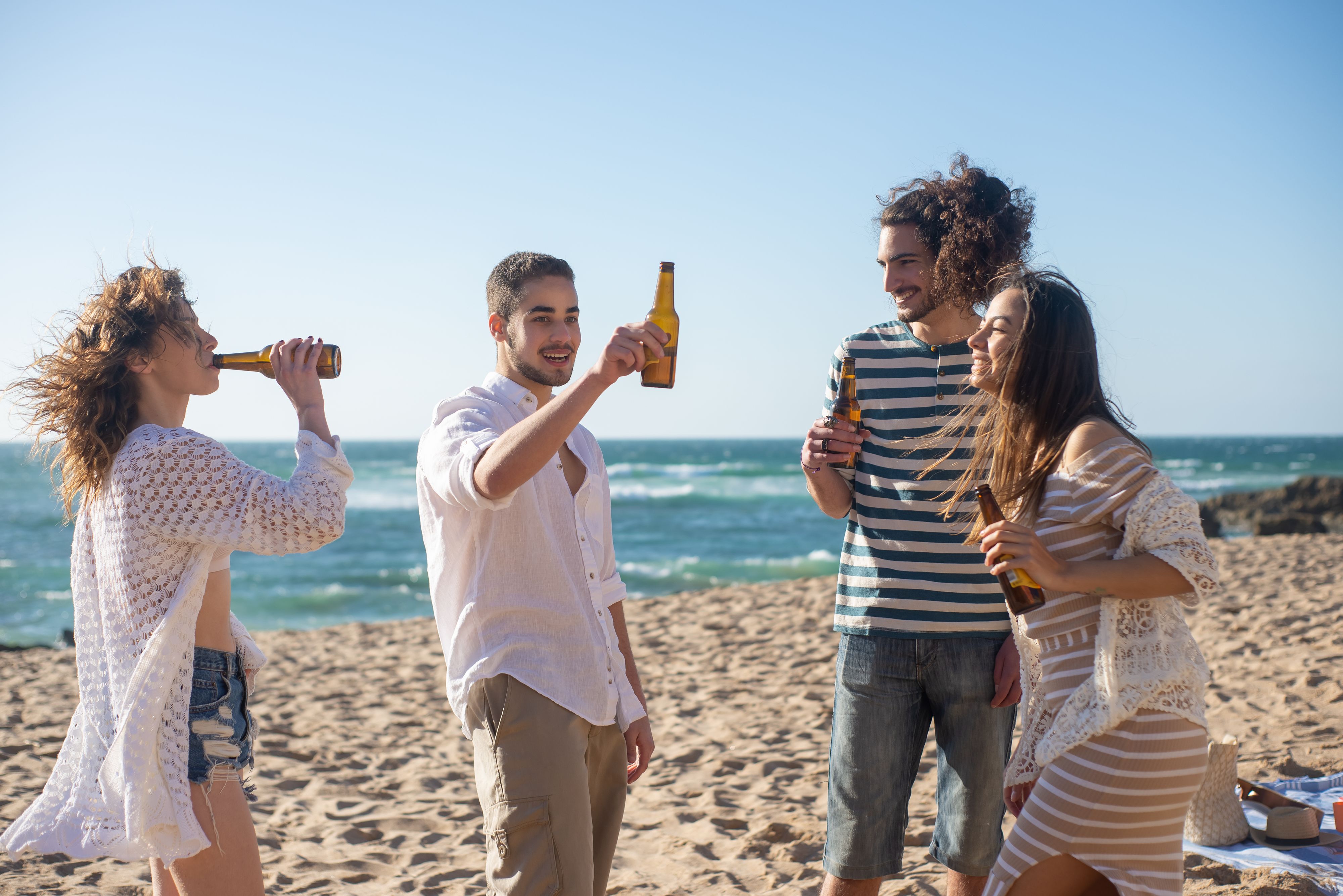 Group of friends toasting on a sunny beach during a bachelor party in Mexico