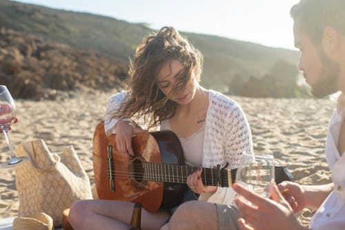 Free A Woman Playing a Guitar in a Picnic Stock Photo