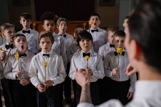 A Boys Choir Singing while Holding Yellow Flowers 