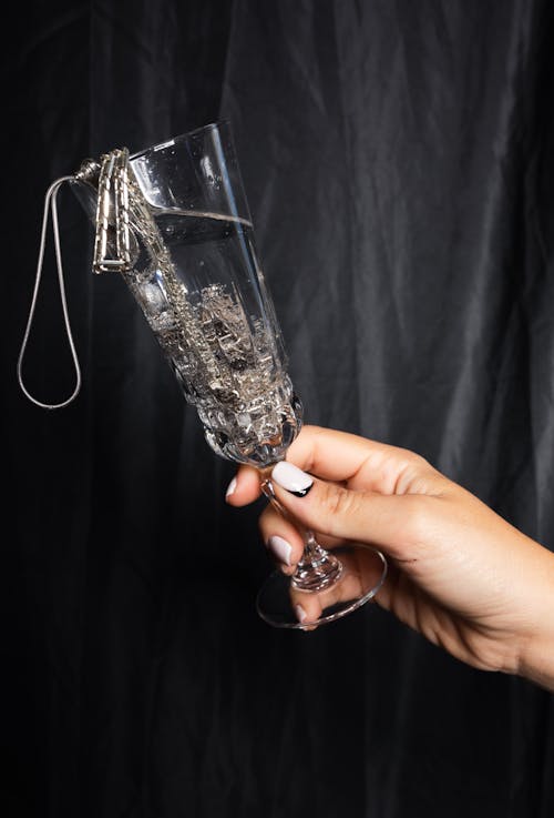Holding a Crystal Champagne Glass Filled with Silver Jewelry