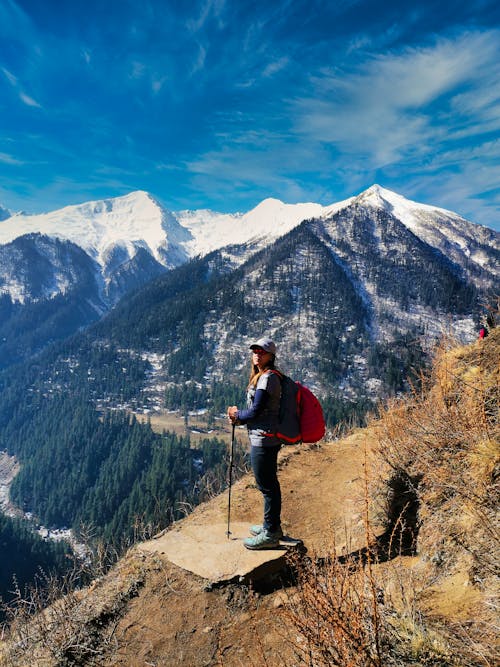 Woman Carrying a Backpack Standing on a Cliff