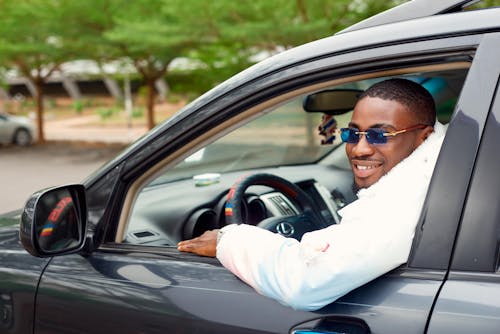 Free A Man in Sunglasses Driving a Car Stock Photo