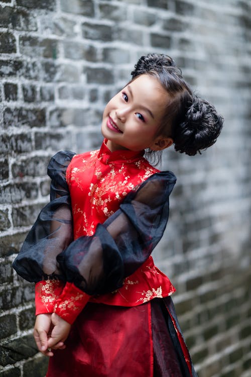 Darmowe zdjęcie z galerii z azjatycka dziewczyna, ceglana ściana, czerwona sukienka