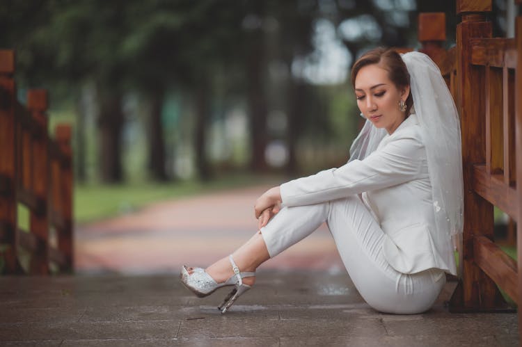 Woman In White Long Sleeve Shirt And White Pants With Veil Sitting On Tiled Floor