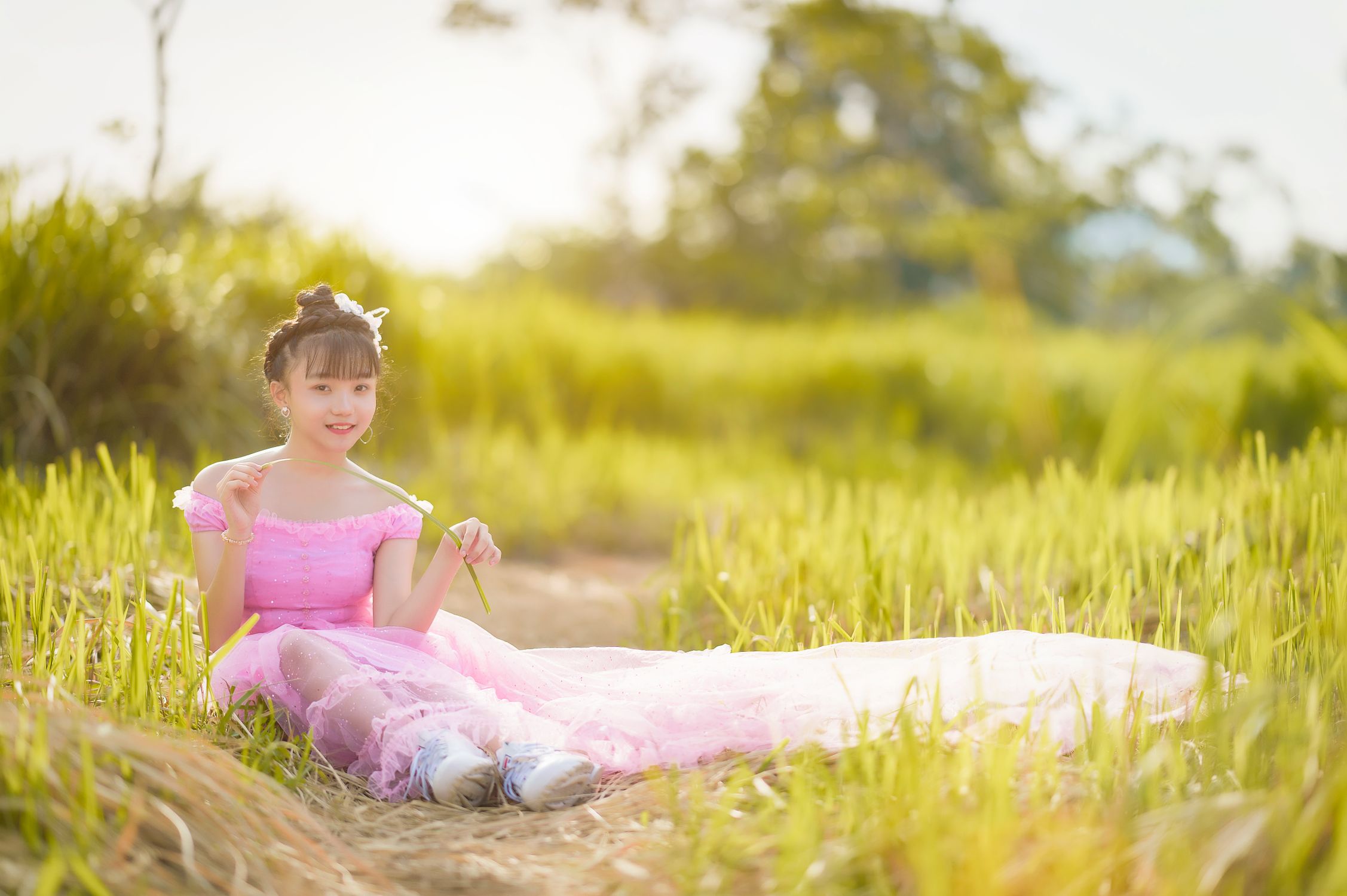 A Girl in Pink Dress Sitting on Green Grass Field · Free Stock Photo