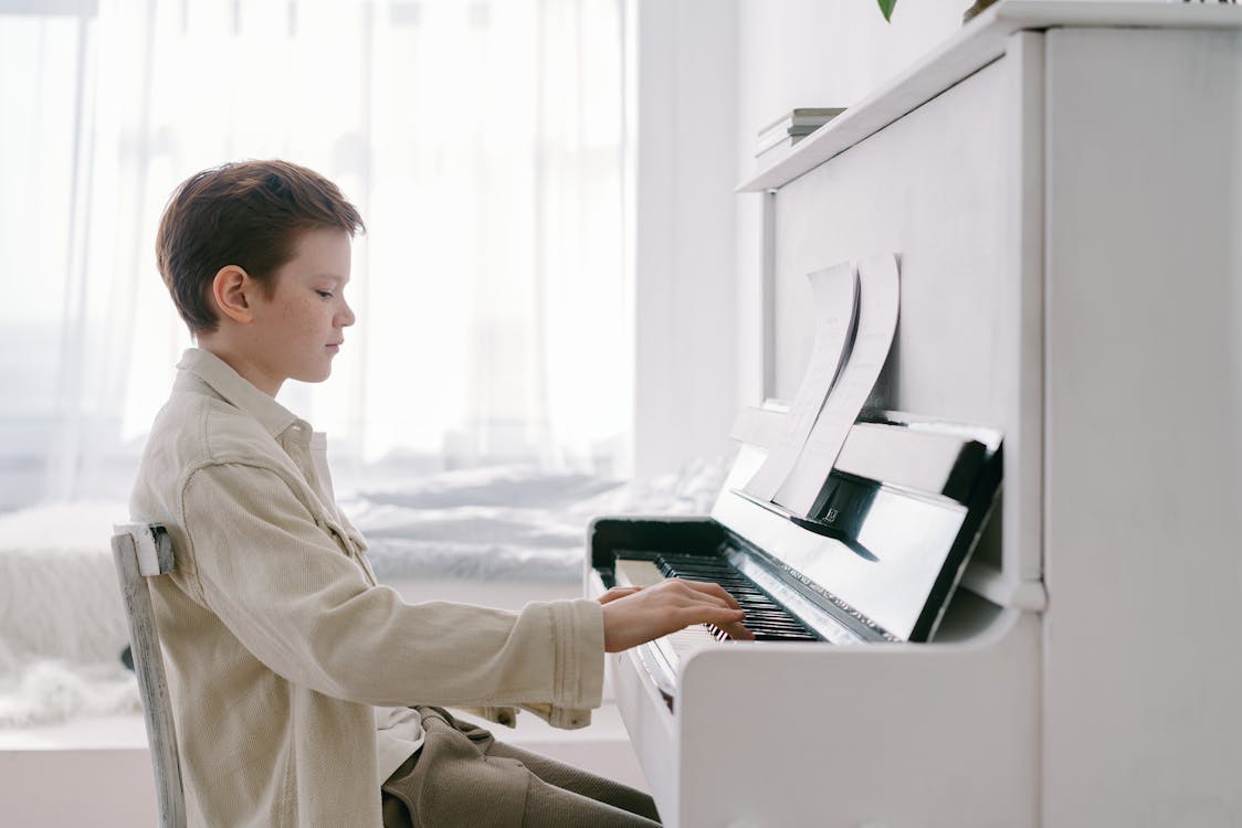 Free A Side View of a Young Boy Playing Piano Stock Photo