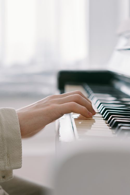 Free A close-up view of an adult's hand playing piano keys, capturing musical expression. Stock Photo