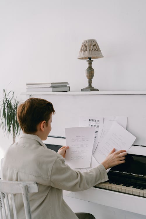 Boy Sitting by the Piano Reading Music Sheets