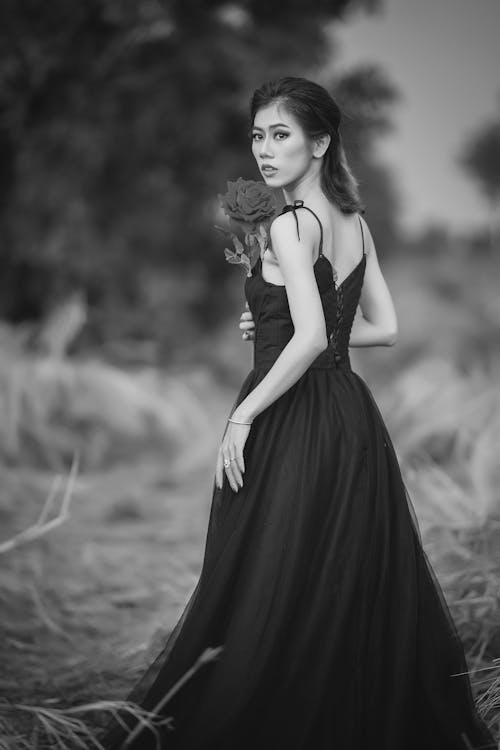 A Grayscale of a Woman Wearing a Black Dress