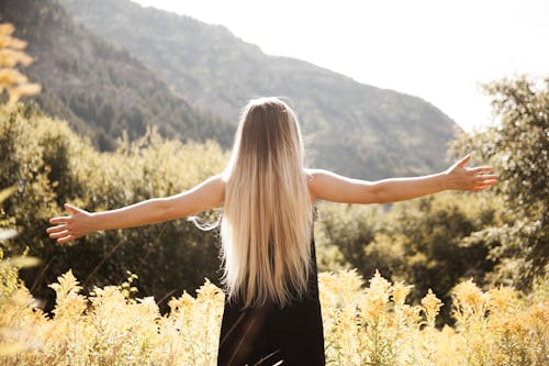 Free Standing Man in Black Dress Facing Mountain Stock Photo