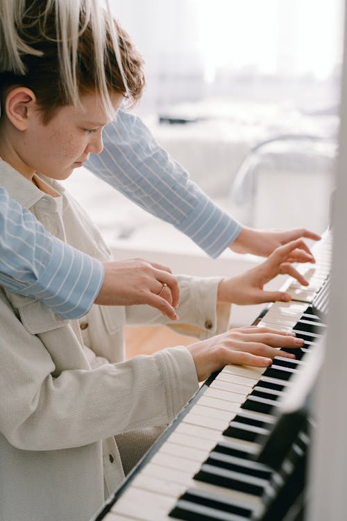 Adult Person Teaching Boy Piano Lesson