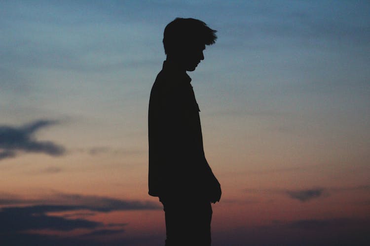 A Silhouette Of A Man Standing In Side View