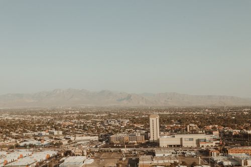 Free Aerial photo showcasing a city's urban sprawl against a mountain backdrop during daytime. Stock Photo