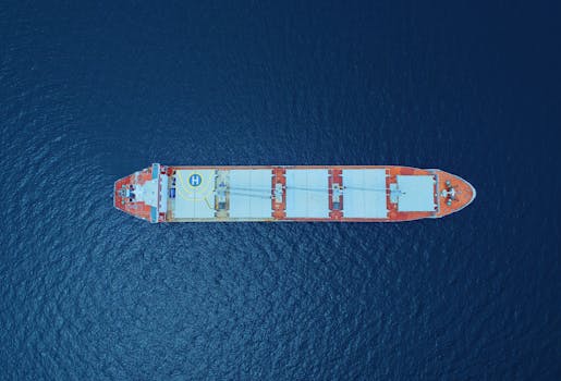 High angle view of a large cargo ship navigating the deep blue ocean in Indonesia.