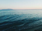 亚历山大鲁波利海滩的日出景色宁静，柔和的天空下波浪轻柔