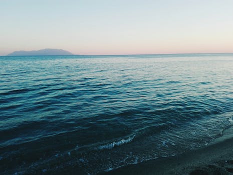 亚历山大鲁波利海滩的日出景色宁静，柔和的天空下波浪轻柔