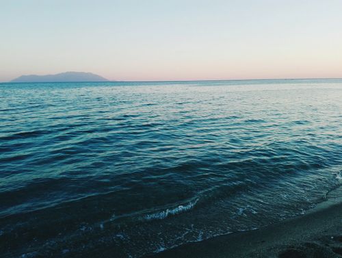 Free Serene sunrise view over Alexandroupoli beach with gentle waves under a pastel sky. Stock Photo
