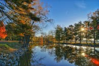 晨光下，色彩缤纷的树木倒映在宁静的秋日湖面上