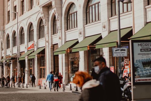 Free Busy city street scene with pedestrians and historic architecture on a sunny day. Stock Photo