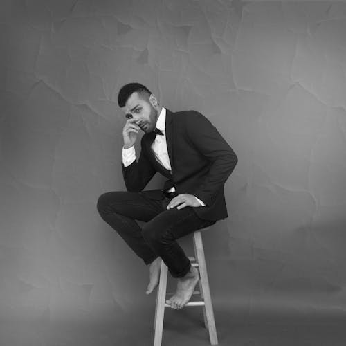 Monochrome Photography of Guy Sitting on Chair