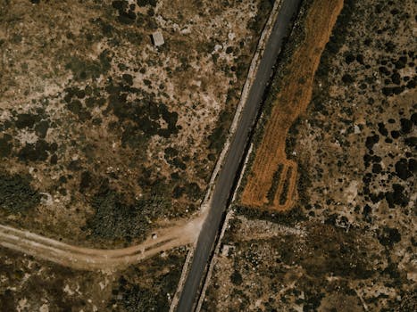 Aerial photo of a rugged landscape near Dingli, Malta showcasing diverse terrain and a winding road.