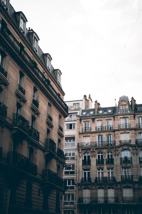 Free Charming European apartment buildings with ornate facades and balconies under a cloudy sky. Stock Photo