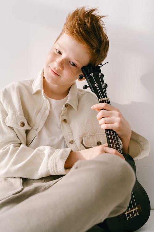 Foto profissional grátis de bonito, garoto, instrumento musical