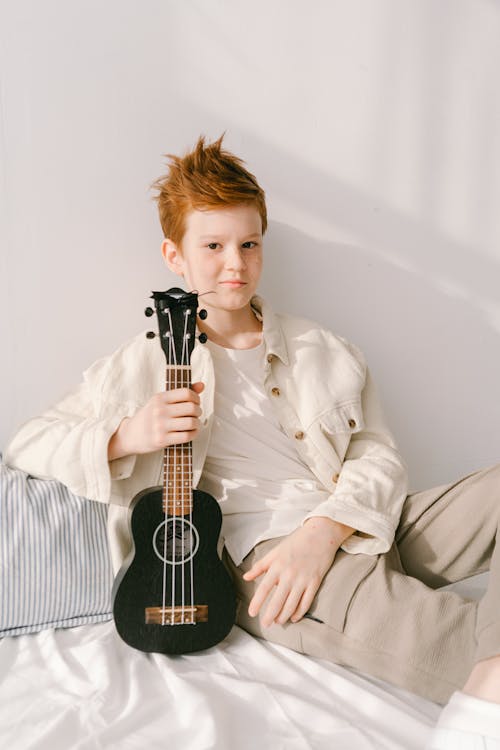 Foto profissional grátis de bonito, garoto, instrumento de cordas