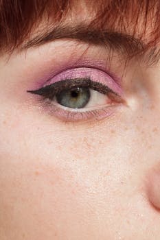 Detailed shot of a green eye featuring pink eyeshadow and bold black eyeliner.