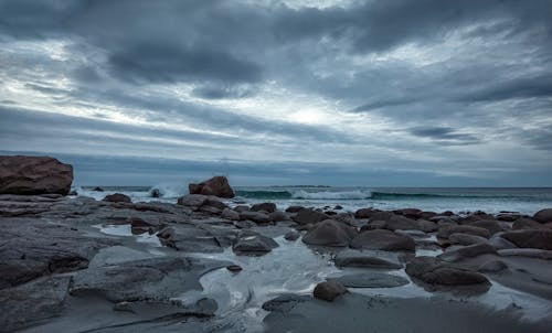 Foto d'estoc gratuïta de cel ennuvolat, cos d'aigua, costa rocallosa