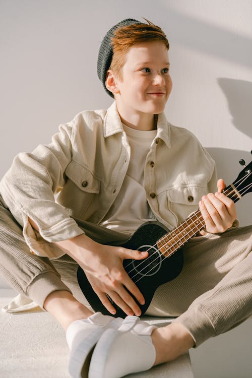 Free A Young Man Wearing a Beanie while Holding Ukulele Stock Photo