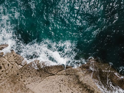 Free Drone shot of waves crashing against the rocky shore in Wied il-Għajn, Malta, showcasing stunning marine beauty. Stock Photo