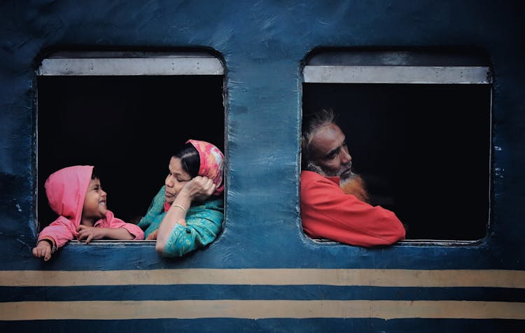 Three People Travelling By A Train