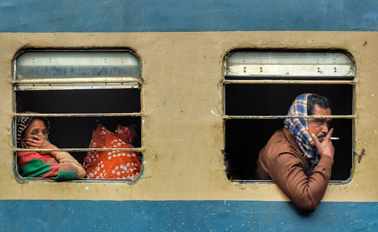 A Woman Sitting Behind A Man Smoking On A Bus