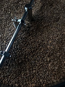 A close-up view of aromatic coffee beans being roasted in a commercial roaster.