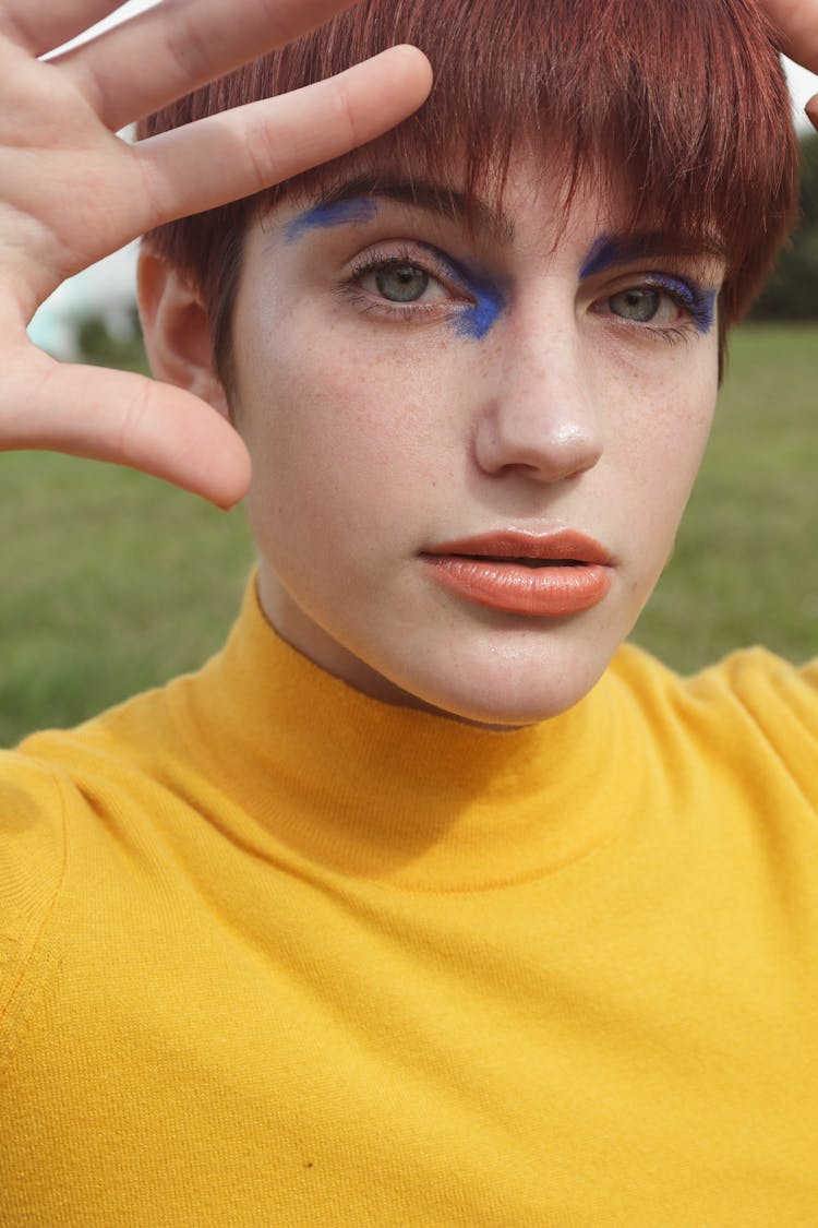 A Woman In Yellow Shirt With Blue Eyeshadow