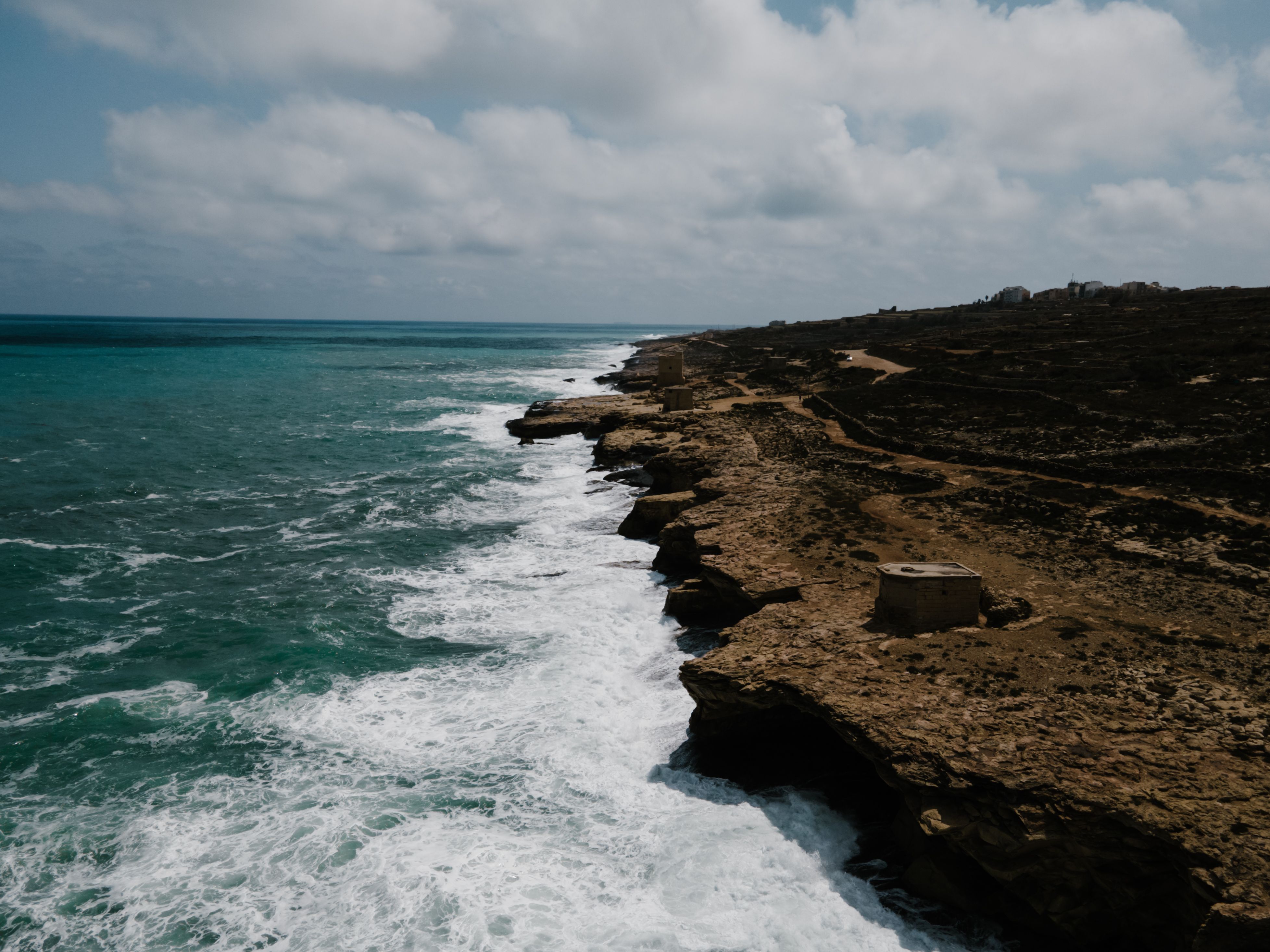 Explore the rugged coastline of Ħaż-Żabbar, Malta, with its stunning seascape and crashing waves.