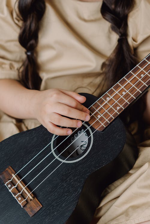 Girl Holding A Black Ukelele